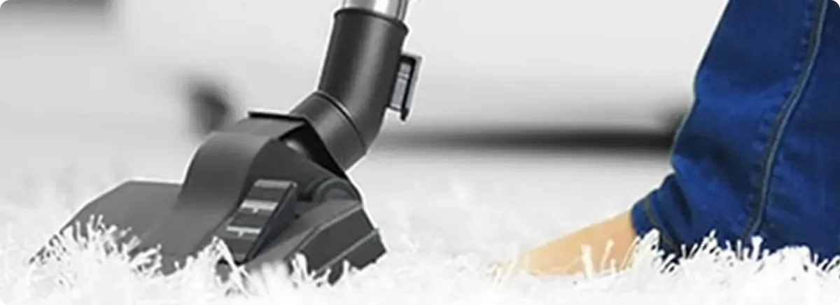 Close-up of a professional vacuuming a white carpet in Bartow.